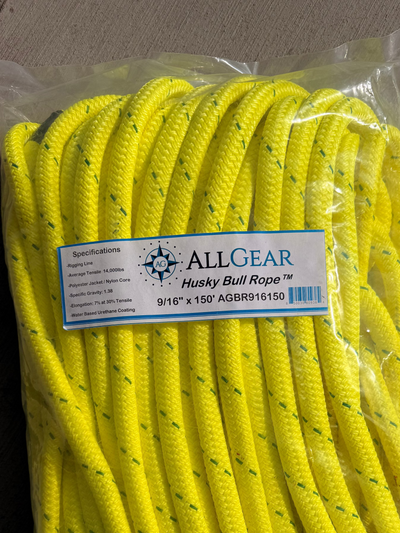 A clear plastic bag containing bright yellow All Gear Husky Bull Rope 9/16" x 150 ft, photographed on a gray concrete surface with a brand label visible on the front.
